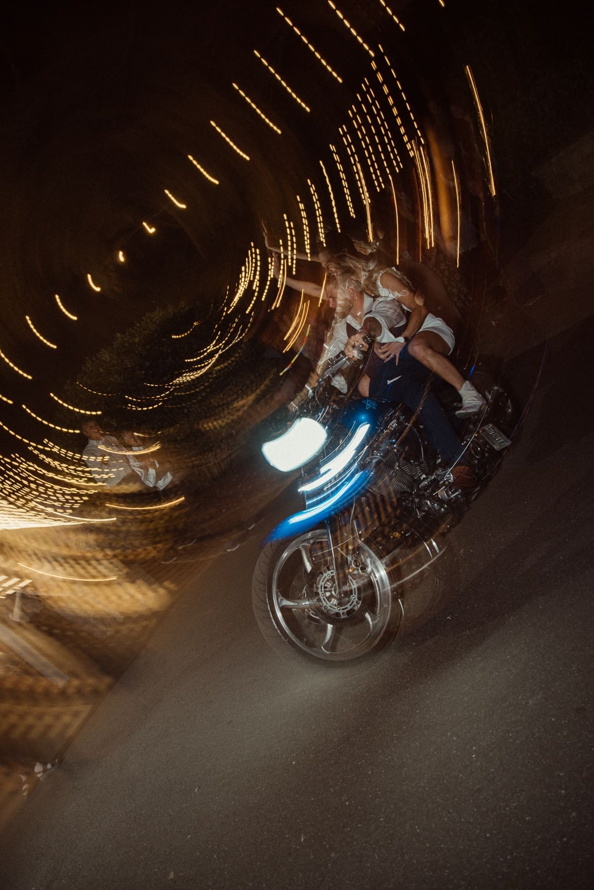 Bride and groom making a motorcycle exit with light trails at Bowing Oaks wedding. 