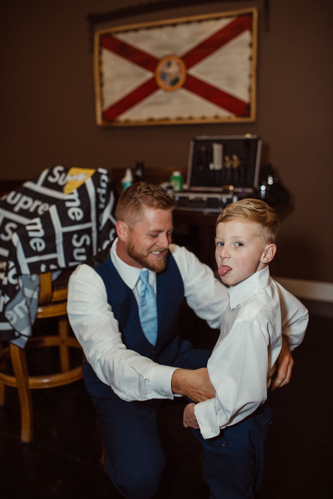 Groom and ring bearer sharing a playful candid moment before the ceremony. 