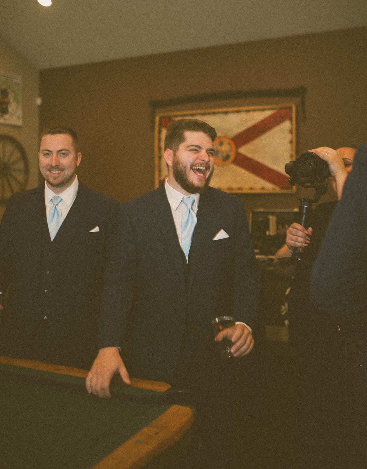 Groomsman laughing during pre-ceremony portraits at Bowing Oaks.