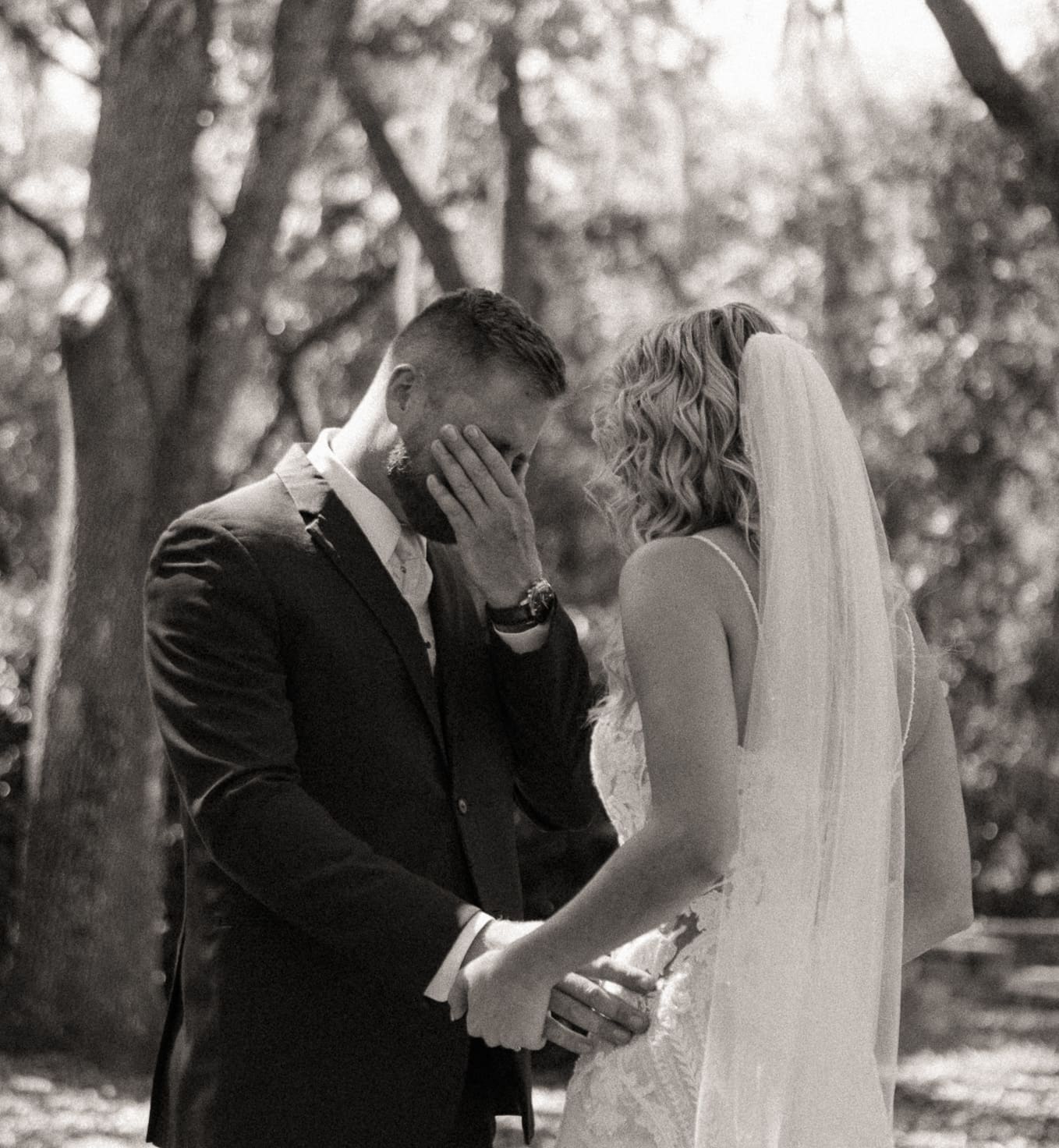 Groom overcome with emotion during first look, black and white wedding photo. 
