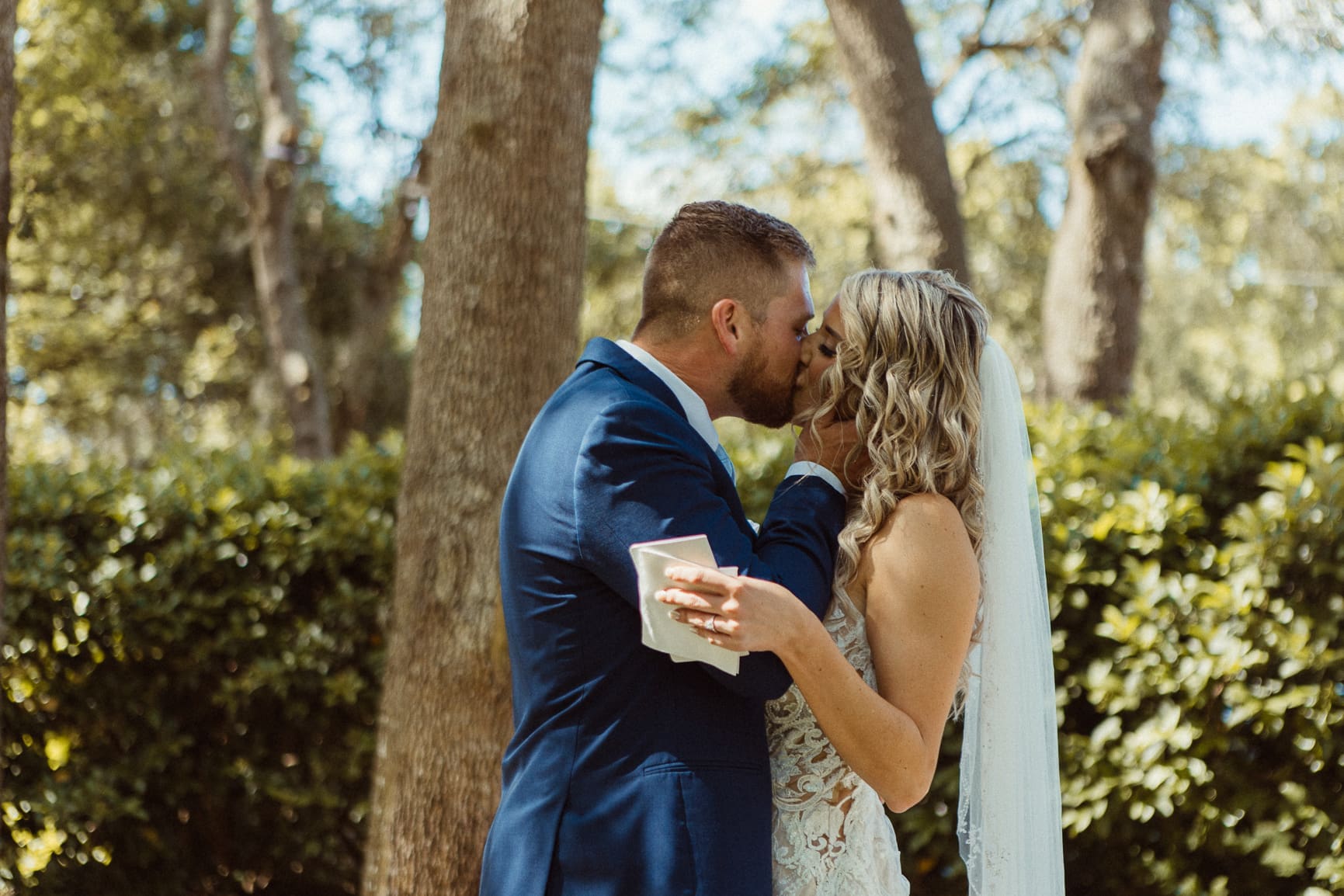 Bride and groom kissing during their private vow reading at Bowing Oaks. 