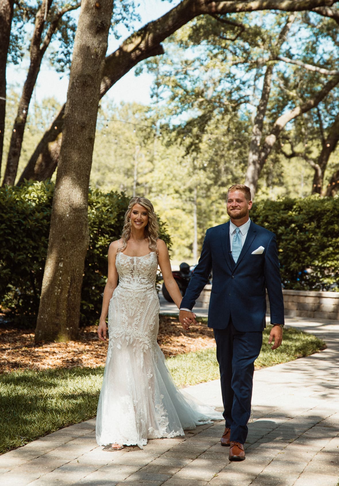 Bride and groom walking hand in hand at their Bowing Oaks wedding. 