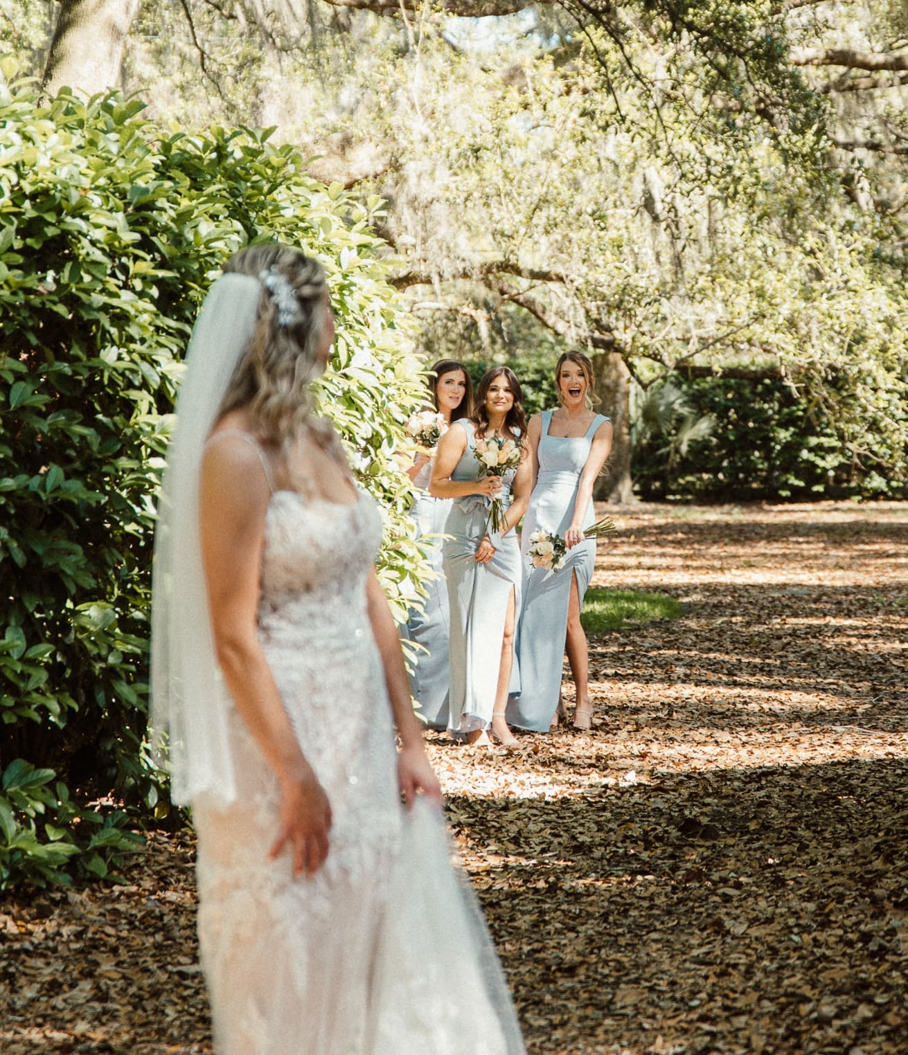 Bridesmaids reacting as they see the bride in her gown at Bowing Oaks