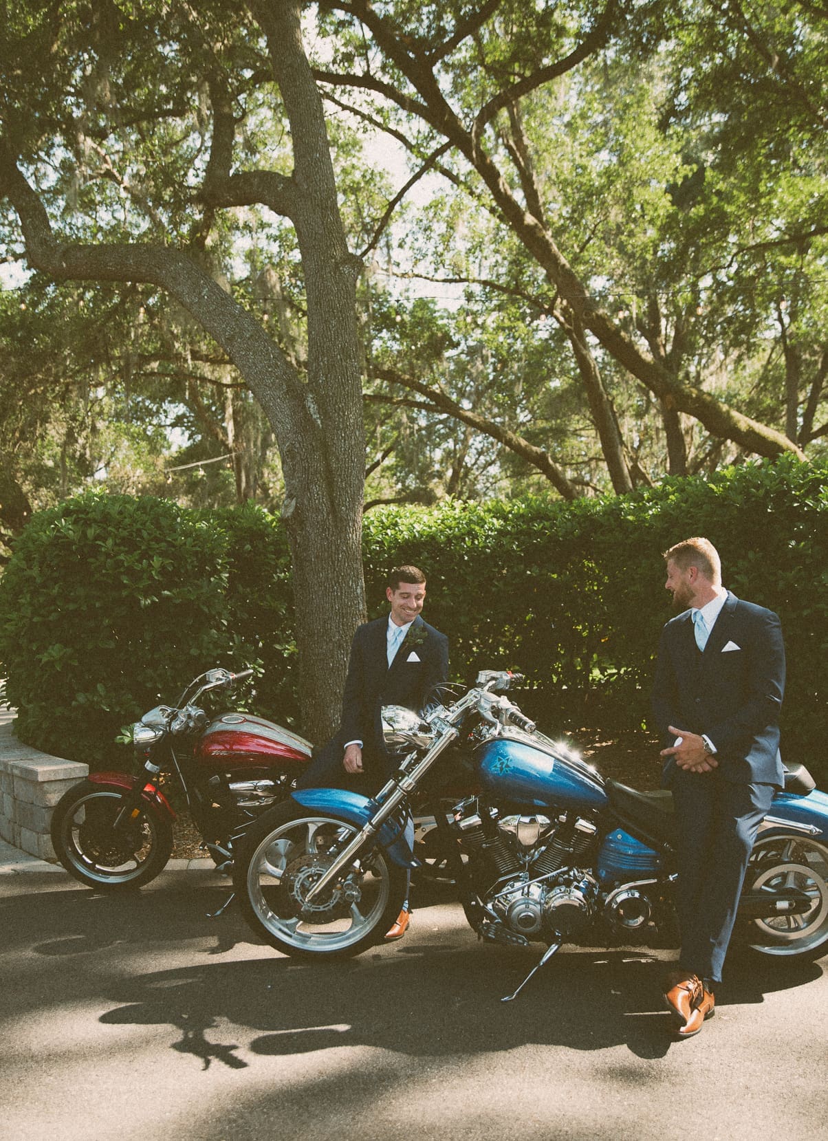 Groomsmen standing beside motorcycles before the ceremony at Bowing Oaks. 