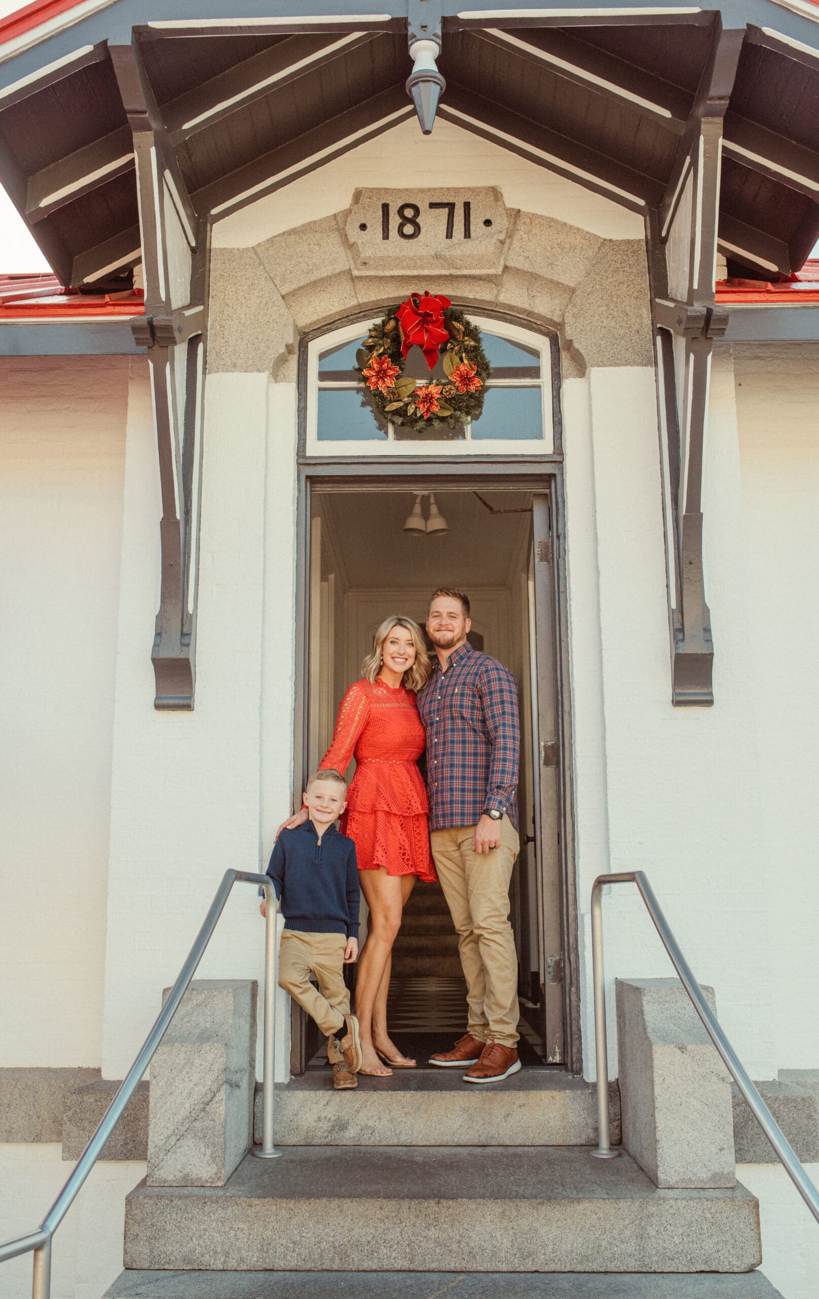 Family standing in the 1871 doorway of the St. Augustine Lighthouse beneath a Christmas wreath