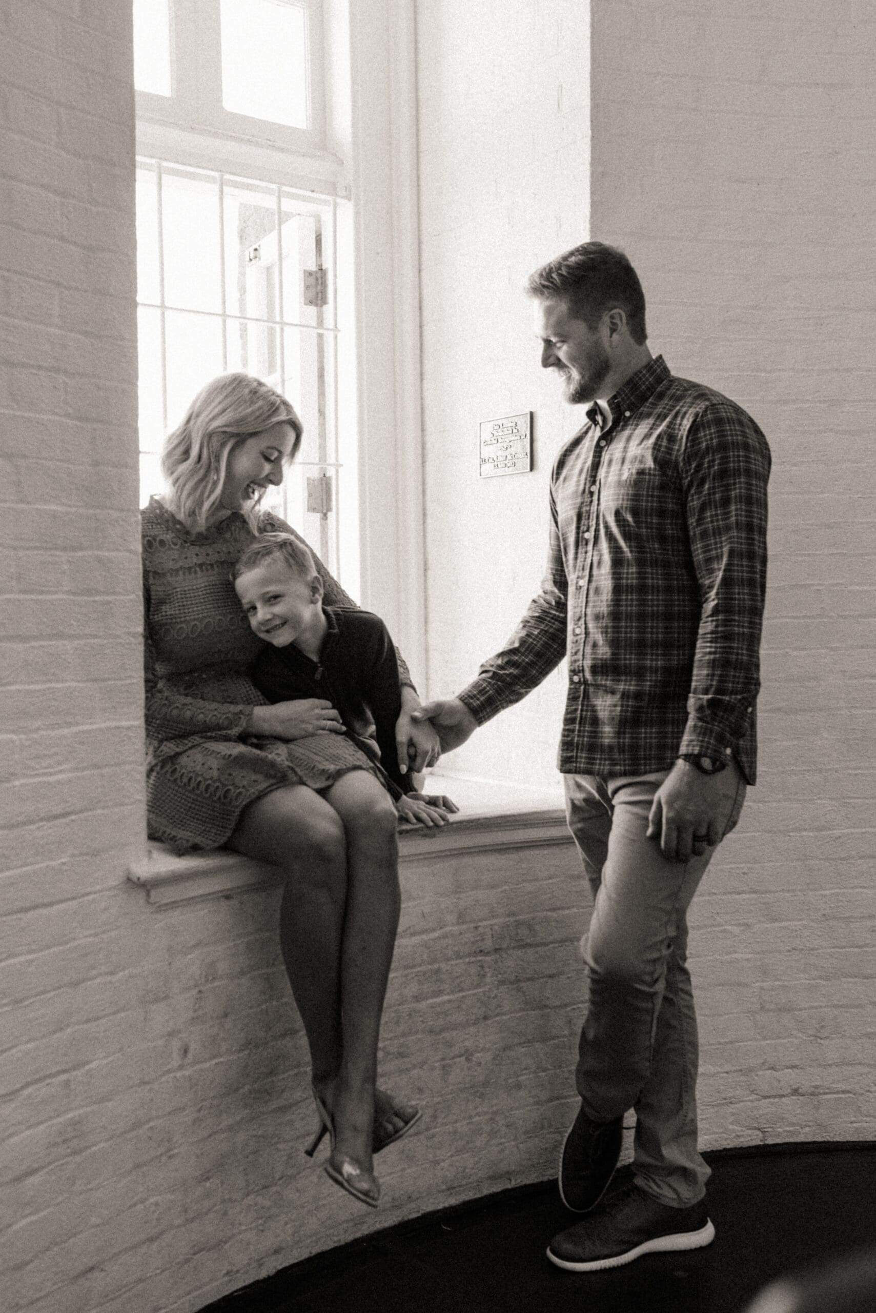 Black and white family engagement photo in a St. Augustine Lighthouse window