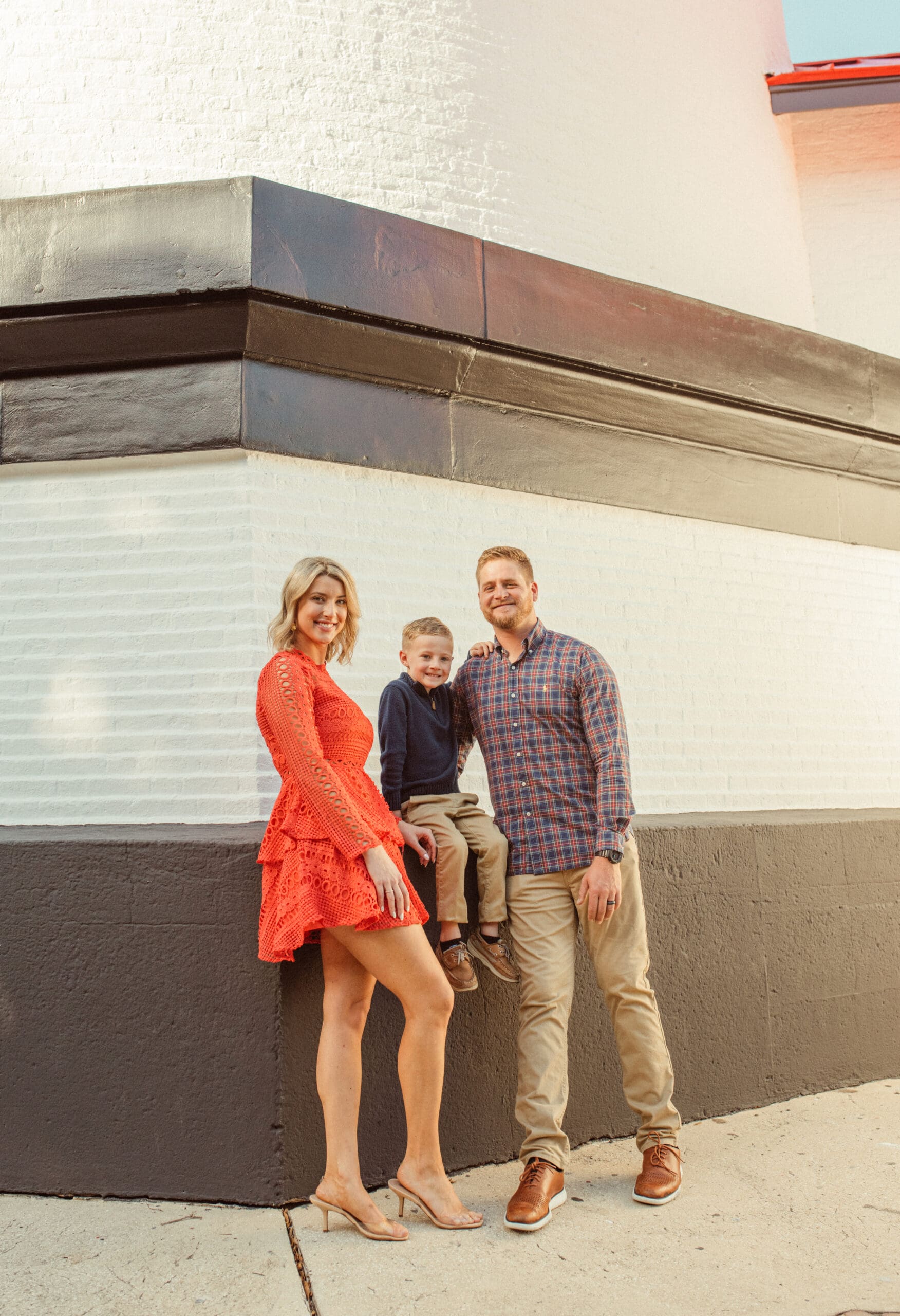 Family smiling together against the base of the St. Augustine Lighthouse