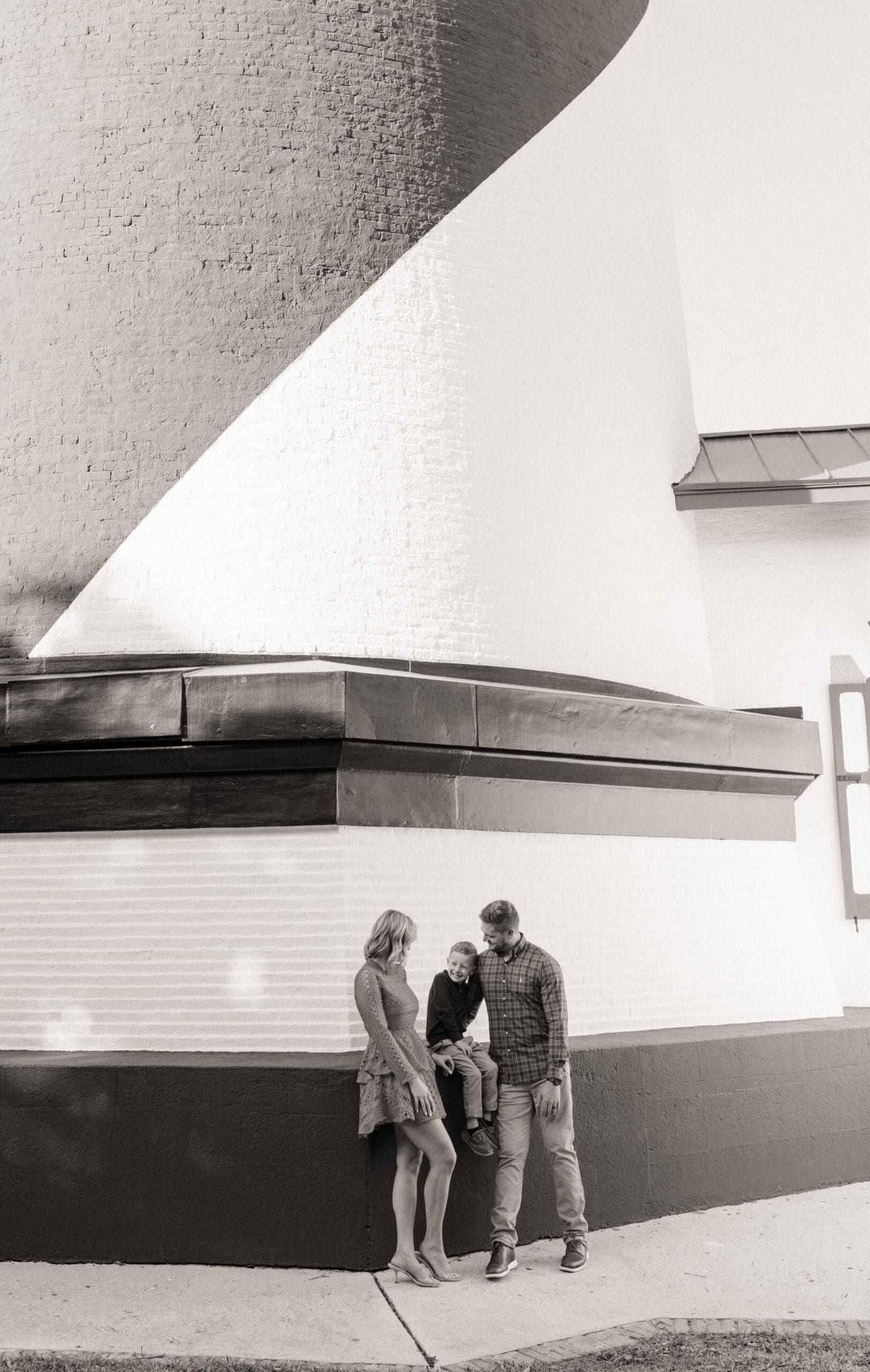 Wide black and white family photo beneath the curve of the St. Augustine Lighthouse