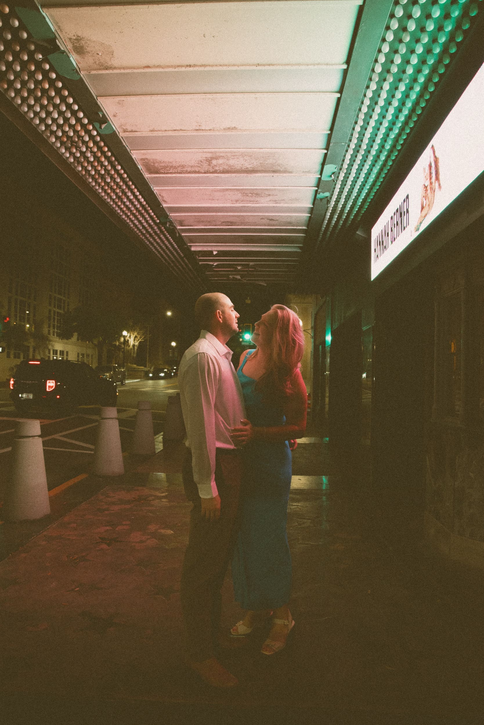 Couple embracing beneath the glowing marquee lights of the Florida Theatre in downtown Jacksonville