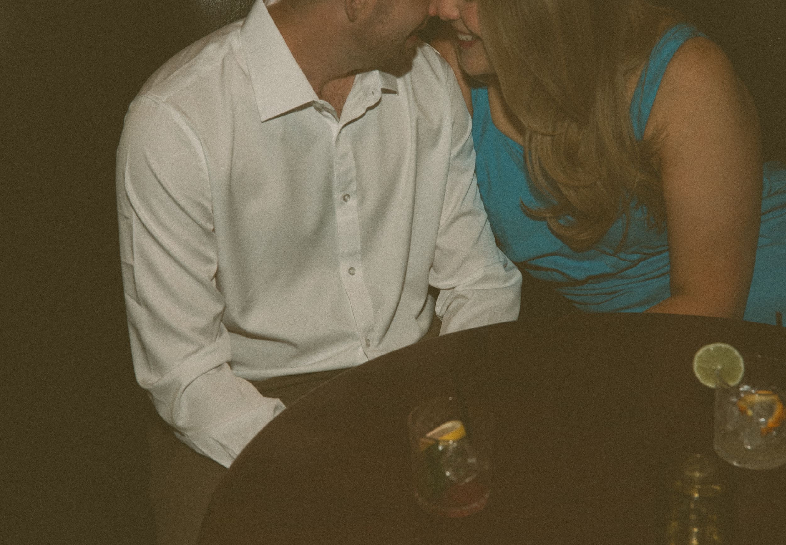 Close-up of a man kissing his smiling fiancée's cheek during a Jacksonville bar engagement session